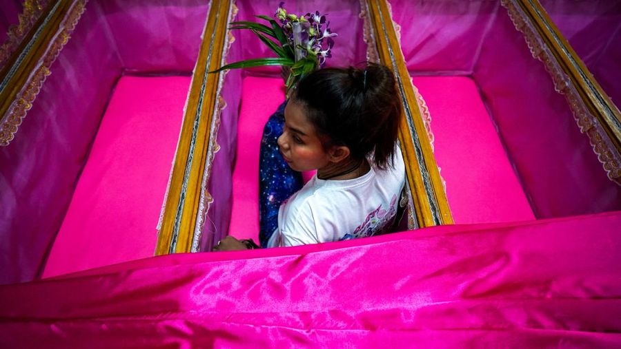 Para penyembah berdoa sambil berdiri di dalam peti mati untuk menyingkirkan nasib buruk dan terlahir kembali untuk awal yang baru di Tahun Baru di sebuah kuil di Nonthaburi, di pinggiran Bangkok, Thailand, 1 Januari 2025. (REUTERS/Athit Perawongmetha)