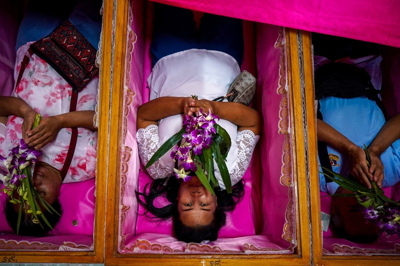 Para penyembah berdoa sambil berdiri di dalam peti mati untuk menyingkirkan nasib buruk dan terlahir kembali untuk awal yang baru di Tahun Baru di sebuah kuil di Nonthaburi, di pinggiran Bangkok, Thailand, 1 Januari 2025. (REUTERS/Athit Perawongmetha)