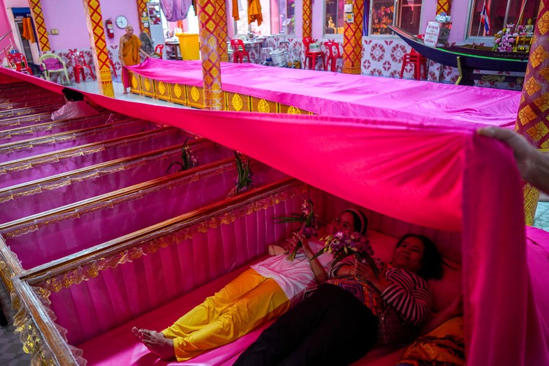 Para penyembah berdoa sambil berdiri di dalam peti mati untuk menyingkirkan nasib buruk dan terlahir kembali untuk awal yang baru di Tahun Baru di sebuah kuil di Nonthaburi, di pinggiran Bangkok, Thailand, 1 Januari 2025. (REUTERS/Athit Perawongmetha)