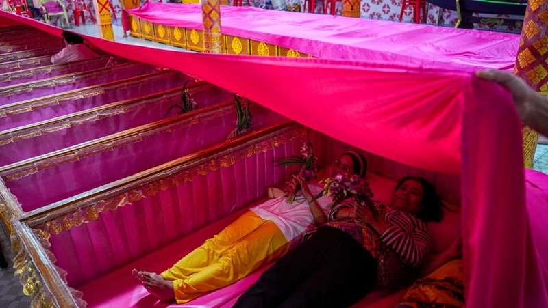 Para penyembah bermohon sembari berdiri di dalam peti meninggal untuk menyingkirkan nasib jelek dan terlahir kembali untuk awal nan baru di Tahun Baru di sebuah kuil di Nonthaburi, di pinggiran Bangkok, Thailand, 1 Januari 2025. Para penyembah bermohon sembari berdiri di dalam peti meninggal untuk menyingkirkan nasib jelek dan terlahir kembali untuk awal nan baru di Tahun Baru di sebuah kuil di Nonthaburi, di pinggiran Bangkok, Thailand, 1 Januari 2025. (REUTERS/Athit Perawongmetha)