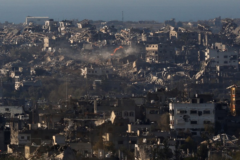 Seorang pria Yahudi Ultra-Ortodoks menyeka wajahnya, dengan latar belakang Gaza utara saat militer Israel melakukan operasi di dalam Jalur Gaza, di tengah konflik yang sedang berlangsung antara Israel dan Hamas, seperti yang terlihat dari Israel selatan, 1 Januari 2025. (REUTERS/Kai Pfaffenbach)