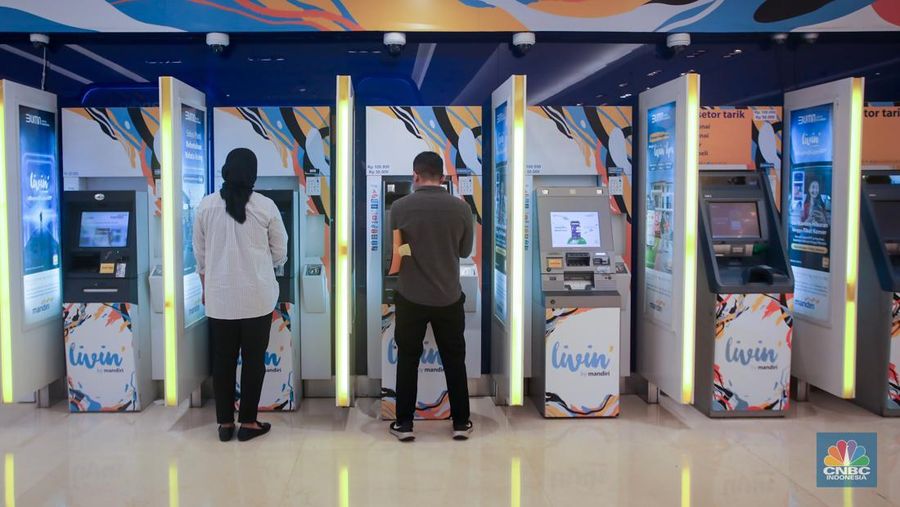 Sejumlah orang melakukan transaksi melalui mesin Anjungan Tunai Mandiri (ATM) di Bank Mandiri. (վ/Faisal Rahman)