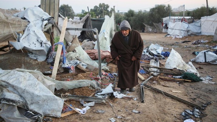 Seorang pria Palestina memeriksa kerusakan di kamp tenda yang menampung orang-orang terlantar, pasca serangan Israel, di tengah konflik Israel-Hamas, di daerah Al-Mawasi, di Khan Younis, Jalur Gaza selatan, 2 Januari 2025. (REUTERS/Hatem Khaled)