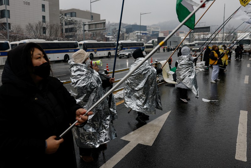 Warga Korea Selatan (Korsel) menerjang badai salju untuk menggelar demonstrasi mendesak Presiden Korsel, Yoon Suk Yeol, yang telah dimakzulkan dan diskors, segera ditangkap. (REUTERS/Tyrone Siu) Warga Korea Selatan (Korsel) menerjang badai salju untuk menggelar demonstrasi mendesak Presiden Korsel, Yoon Suk Yeol, yang telah dimakzulkan dan diskors, segera ditangkap. (REUTERS/Tyrone Siu)