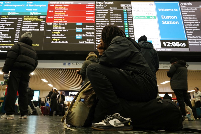 Penumpang melihat papan keberangkatan di Stasiun Euston, London, Inggris, 5 Januari 2025. (REUTERS/Hollie Adams)