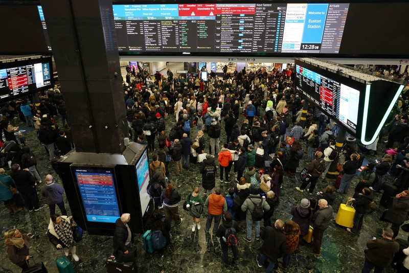Penumpang melihat papan keberangkatan di Stasiun Euston, London, Inggris, 5 Januari 2025. (REUTERS/Hollie Adams)