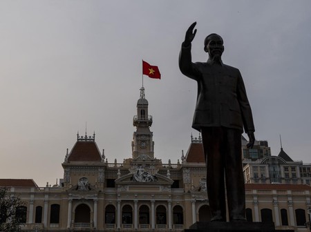 Bendera Vietnam berkibar di atas balai kota di belakang patung Ho Chi Minh di Kota Ho Chi Minh, Vietnam, Jumat, 12 Januari 2024. (AP Photo/Jae C. Hong/File Foto)