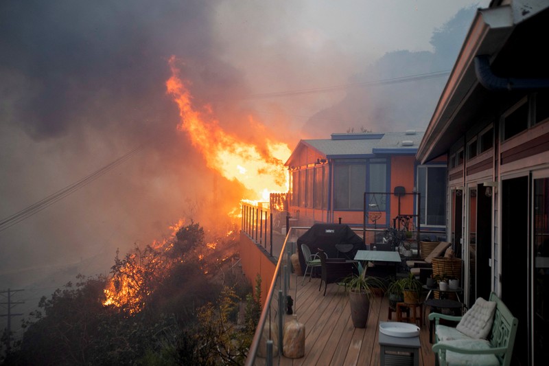 Asap mengepul dari kebakaran hutan yang terjadi di dekat Pacific Palisades di sisi barat Los Angeles selama badai angin yang disebabkan cuaca buruk, di Los Angeles, California, 7 Januari 2025. (REUTERS/Daniel Cole)