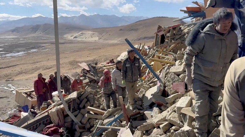 Tim penyelamat bekerja di tengah puing-puing setelah gempa bumi di lokasi yang disebutkan sebagai Kota Shigatse, Daerah Otonomi Tibet, China, dalam tangkapan layar yang diperoleh dari video selebaran yang dirilis pada 7 Januari 2025. (Tibet Fire and Rescue/Handout via REUTERS)