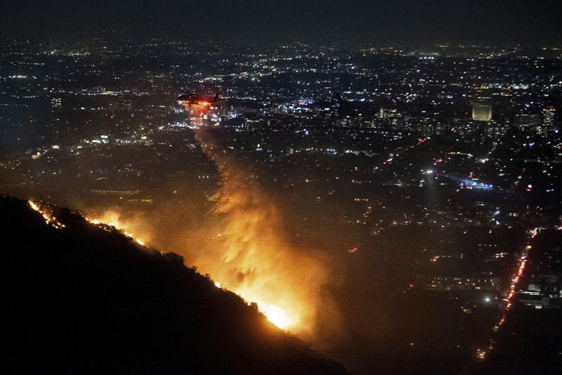 Helikopter menyemprotkan air ke lokasi kebakaran Sunset Fire di kawasan Hollywood Hills, Los Angeles, Rabu, 8 Januari 2025. (AP/Ethan Swope) Helikopter menyemprotkan air ke lokasi kebakaran Sunset Fire di kawasan Hollywood Hills, Los Angeles, Rabu, 8 Januari 2025. (AP/Ethan Swope)