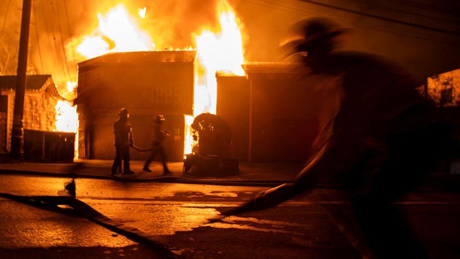 Helikopter menyemprotkan air ke lokasi kebakaran Sunset Fire di kawasan Hollywood Hills, Los Angeles, Rabu, 8 Januari 2025. (AP/Ethan Swope)