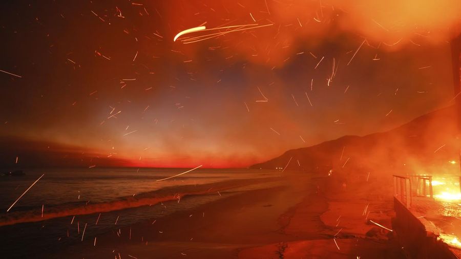 Helikopter menyemprotkan air ke lokasi kebakaran Sunset Fire di kawasan Hollywood Hills, Los Angeles, Rabu, 8 Januari 2025. (AP/Ethan Swope)