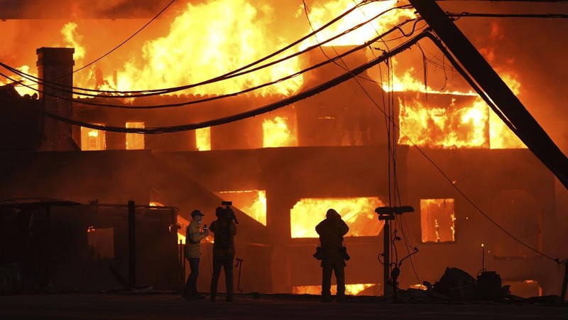 Helikopter menyemprotkan air ke lokasi kebakaran Sunset Fire di kawasan Hollywood Hills, Los Angeles, Rabu, 8 Januari 2025. (AP/Ethan Swope)