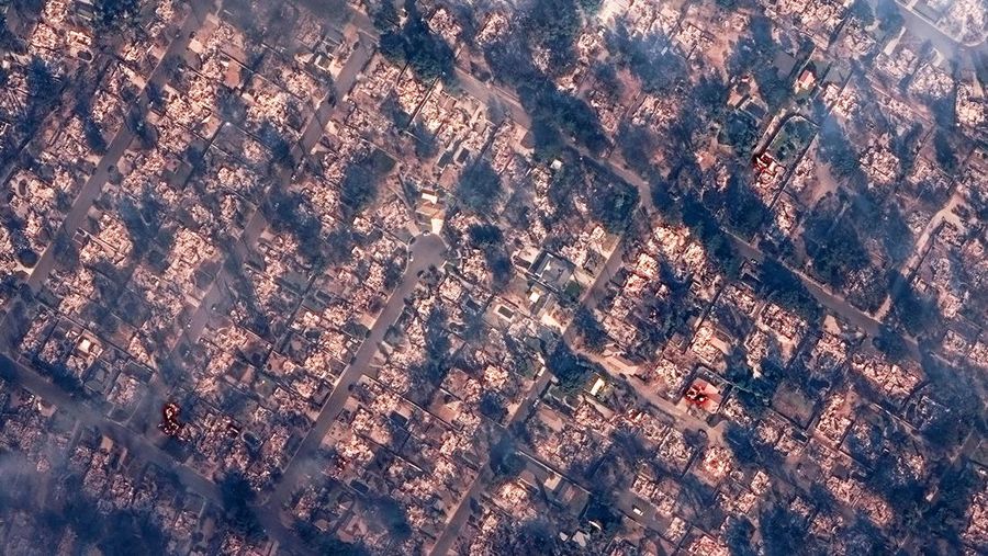 Citra satelit menunjukkan asap menutupi rumah-rumah setelah kebakaran hutan yang dahsyat, di Altadena, California, AS, 8 Januari 2025. (Maxar Technologies/Handout via REUTERS)