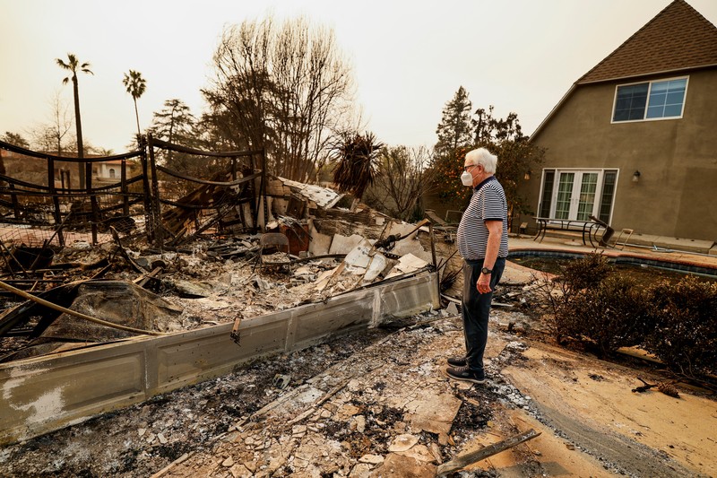 Seorang yang membawa bendera berjalan menjauh dari rumah yang terbakar saat angin kencang yang memicu kebakaran hutan yang dahsyat di wilayah Los Angeles memaksa orang-orang untuk mengungsi, di Kebakaran Eaton di Altadena, California, AS, 8 Januari 2025. (REUTERS/David Swanson) Seorang yang membawa bendera berjalan menjauh dari rumah yang terbakar saat angin kencang yang memicu kebakaran hutan yang dahsyat di wilayah Los Angeles memaksa orang-orang untuk mengungsi, di Kebakaran Eaton di Altadena, California, AS, 8 Januari 2025. (REUTERS/David Swanson)