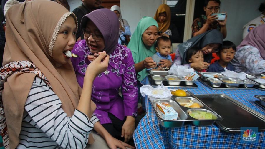 Warga menyantap hidangan Makan Bergizi Gratis (MBG) di kawasan Ciracas, Jakarta, Jumat (10/1/2025). Pemerintah memulai program MBG untuk ibu hamil, ibu menyusui, dan anak balita di Posyandu Anyelir 1 dan Posyandu Dahlia 2. (CNBC Indonesia/Faisal Rahman)