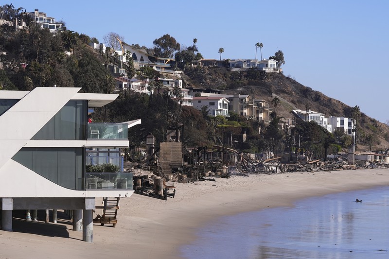 Rumah-rumah yang hancur akibat Kebakaran Palisades di sepanjang Pacific Coast Highway di Malibu, California, Minggu (12/1/2024). (AP Photo/Mark J. Terrill)