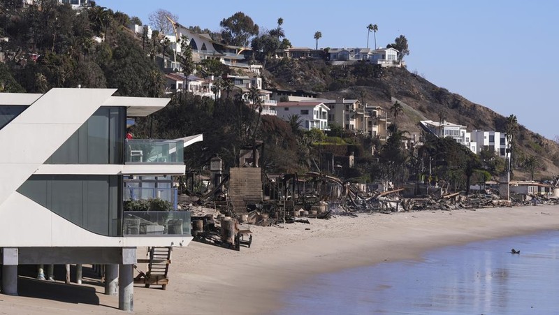 Rumah-rumah yang hancur akibat Kebakaran Palisades di sepanjang Pacific Coast Highway di Malibu, California, Minggu (12/1/2024). (AP Photo/Mark J. Terrill)