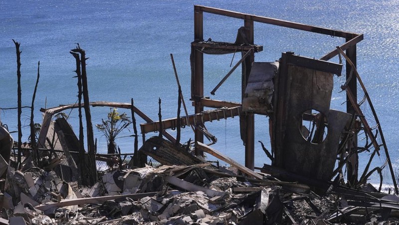 Rumah-rumah yang hancur akibat Kebakaran Palisades di sepanjang Pacific Coast Highway di Malibu, California, Minggu (12/1/2024). (AP Photo/Mark J. Terrill)