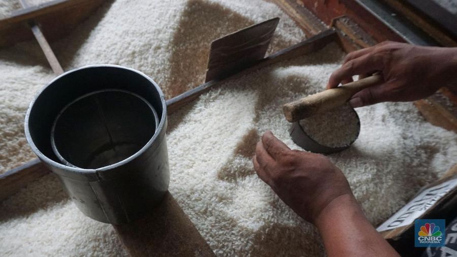 Pekerja menata beras di toko eceran beras di Kawasan Menteng Pulo, Jakarta, Selasa (14/1/2025). (CNBC Indonesia/Muhammad Sabki)