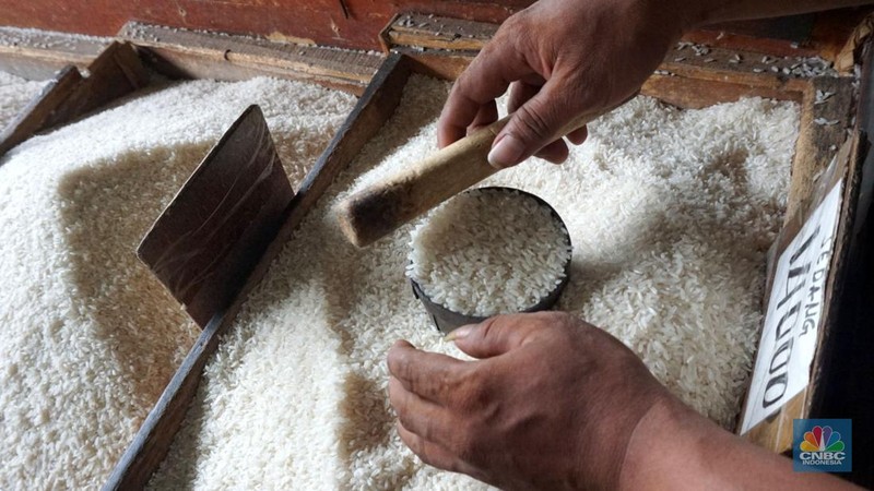 Pekerja menata beras di toko eceran beras di Kawasan Menteng Pulo, Jakarta, Selasa (14/1/2025). (CNBC Indonesia/Muhammad Sabki)