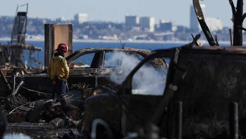 Sisa-sisa mobil rumah yang terbakar tergeletak di tanah, setelah angin kencang yang memicu kebakaran hutan yang dahsyat di wilayah Los Angeles memaksa orang-orang untuk mengungsi, di lingkungan Pacific Palisades di sisi barat Los Angeles, California, AS, 13 Januari 2025. (REUTERS/Daniel Cole)