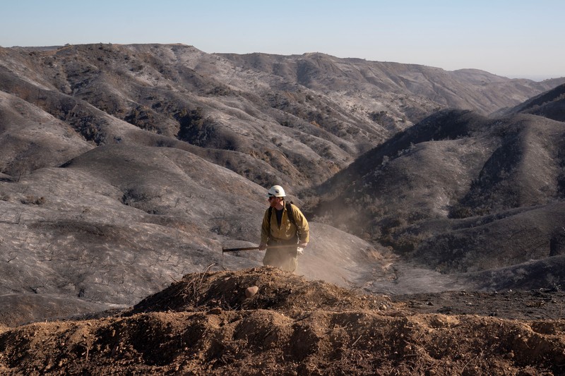 Petugas pemadam kebakaran dari Meksiko beristirahat sambil mendaki ke tujuan mereka untuk memotong garis penahanan di daerah Tarzana selama Kebakaran Palisades di Los Angeles, California, AS, 13 Januari 2025. Petugas pemadam kebakaran dari Meksiko beristirahat sambil mendaki ke tujuan mereka untuk memotong garis penahanan di daerah Tarzana selama Kebakaran Palisades di Los Angeles, California, AS, 13 Januari 2025. (REUTERS/David Ryder)