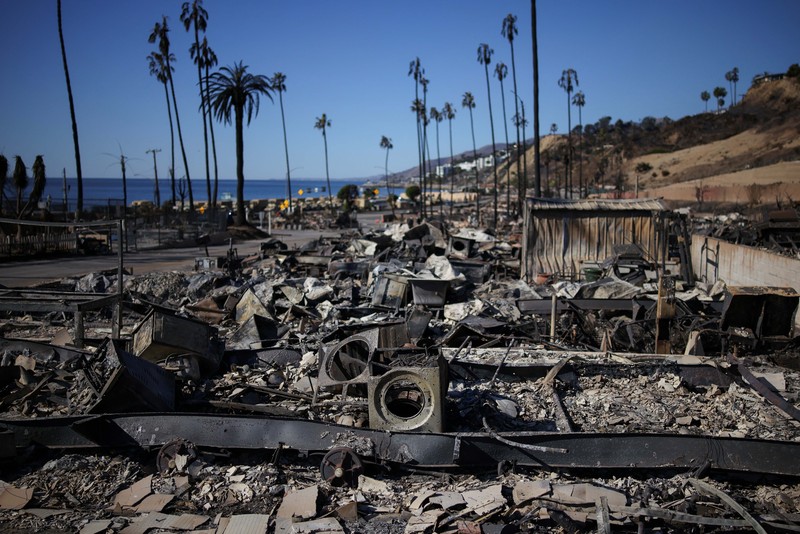 Sisa-sisa mobil rumah yang terbakar tergeletak di tanah, setelah angin kencang yang memicu kebakaran hutan yang dahsyat di wilayah Los Angeles memaksa orang-orang untuk mengungsi, di lingkungan Pacific Palisades di sisi barat Los Angeles, California, AS, 13 Januari 2025. (REUTERS/Daniel Cole)