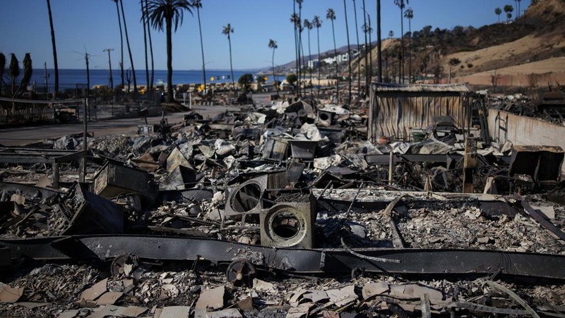 Sisa-sisa mobil rumah yang terbakar tergeletak di tanah, setelah angin kencang yang memicu kebakaran hutan yang dahsyat di wilayah Los Angeles memaksa orang-orang untuk mengungsi, di lingkungan Pacific Palisades di sisi barat Los Angeles, California, AS, 13 Januari 2025. (REUTERS/Daniel Cole)