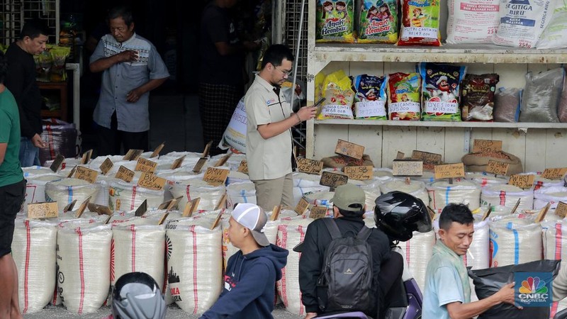 Pekerja menata beras di toko eceran beras di Kawasan Menteng Pulo, Jakarta, Selasa (14/1/2025). (CNBC Indonesia/Muhammad Sabki)