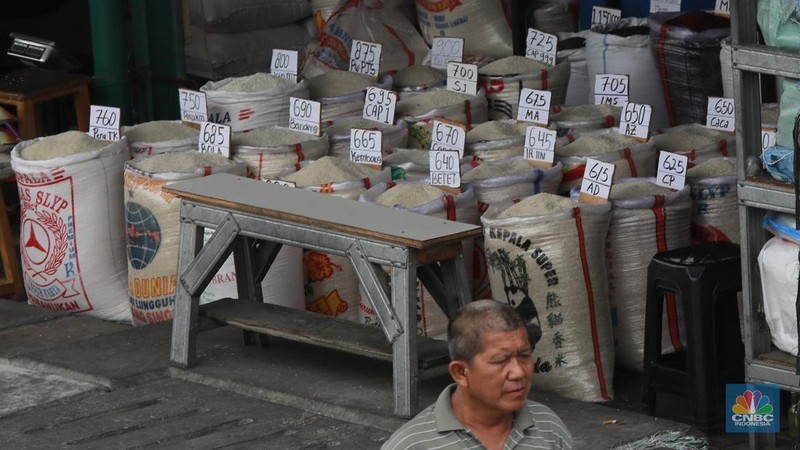 Pekerja menata beras di toko eceran beras di Kawasan Menteng Pulo, Jakarta, Selasa (14/1/2025). (CNBC Indonesia/Muhammad Sabki)