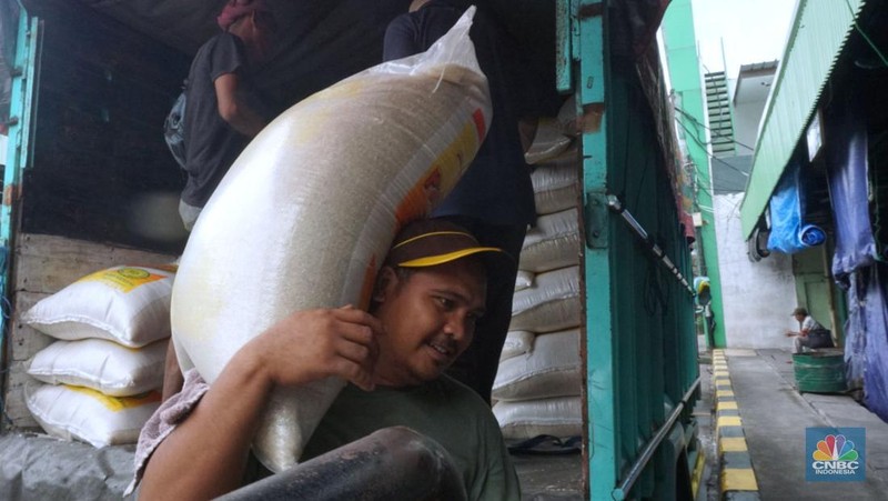 Pekerja menata beras di toko eceran beras di Kawasan Menteng Pulo, Jakarta, Selasa (14/1/2025). (CNBC Indonesia/Muhammad Sabki)