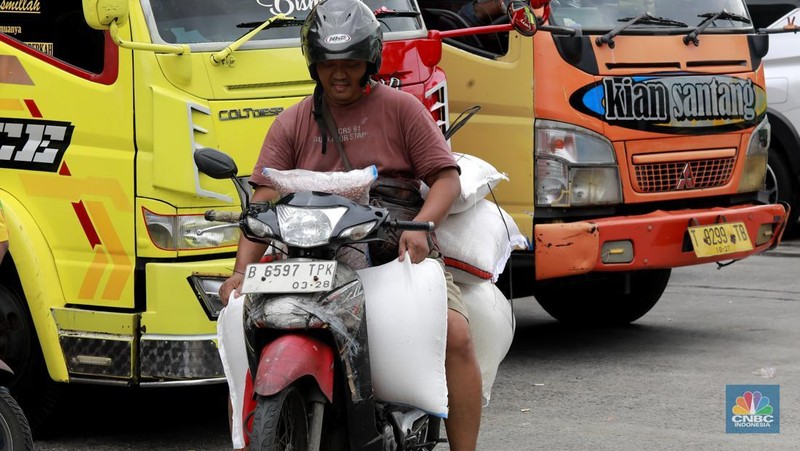 Pekerja menata beras di toko eceran beras di Kawasan Menteng Pulo, Jakarta, Selasa (14/1/2025). (CNBC Indonesia/Muhammad Sabki)