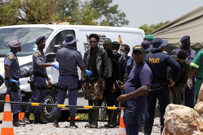 Petugas forensik membawa jenazah dalam kantong jenazah biru selama operasi penyelamatan para penambang dari bawah tanah di tambang emas terbengkalai di Stilfontein, Afrika Selatan, Selasa, 14 Januari 2025. (AP Photo/Themba Hadebe)