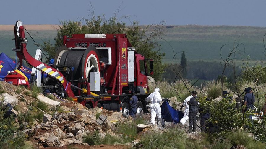 Petugas forensik membawa jenazah dalam kantong jenazah biru selama operasi penyelamatan para penambang dari bawah tanah di tambang emas terbengkalai di Stilfontein, Afrika Selatan, Selasa, 14 Januari 2025. (AP Photo/Themba Hadebe)