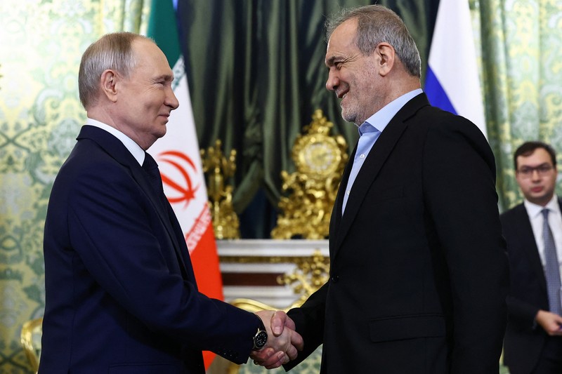 Presiden Rusia Vladimir Putin dan Presiden Iran Masoud Pezeshkian berjabat tangan saat bertemu di Moskow, Rusia, 17 Januari 2025. (REUTERS/Evgenia Novozhenina/Pool)