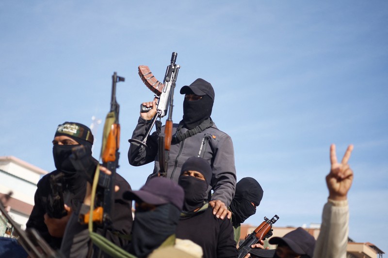 Militan Palestina merayakan meskipun ada penundaan gencatan senjata antara Israel dan Hamas mengenai daftar sandera, di Khan Younis di Jalur Gaza selatan, 19 Januari 2025. Militan Palestina merayakan meskipun ada penundaan gencatan senjata antara Israel dan Hamas mengenai daftar sandera, di Khan Younis di Jalur Gaza selatan, 19 Januari 2025. (REUTERS/Mohammed Salem)