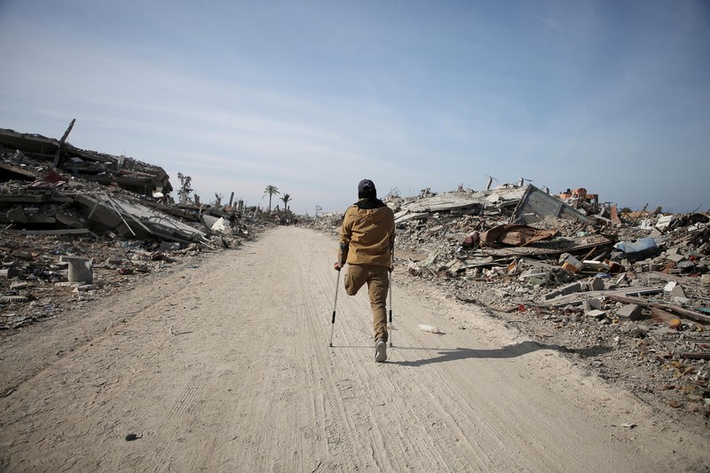 Warga Palestina yang mengungsi berjalan melewati puing-puing saat mencoba kembali ke rumah mereka menyusul penundaan gencatan senjata antara Israel dan Hamas mengenai daftar sandera, di Jalur Gaza utara 19 Januari 2025. Warga Palestina yang mengungsi berjalan melewati puing-puing saat mencoba kembali ke rumah mereka menyusul penundaan gencatan senjata antara Israel dan Hamas mengenai daftar sandera, di Jalur Gaza utara 19 Januari 2025. (REUTERS/Khalil Ramzi)