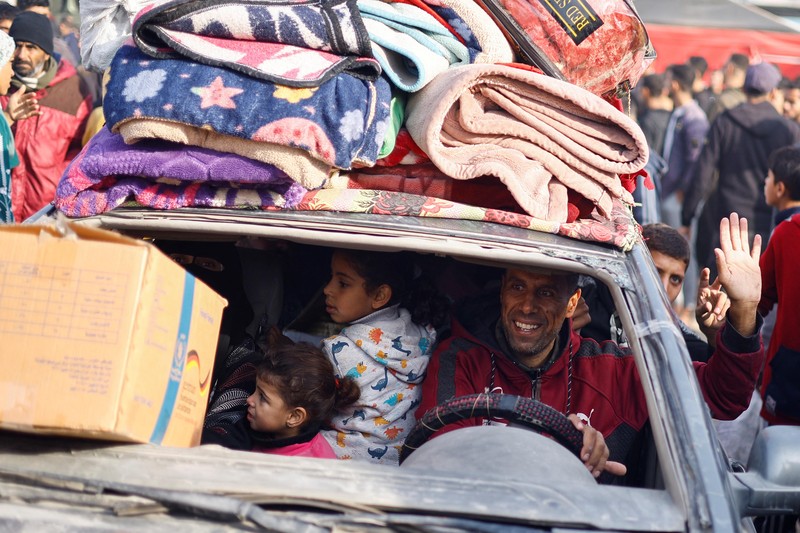 Warga Palestina yang mengungsi berjalan melewati puing-puing saat mencoba kembali ke rumah mereka menyusul penundaan gencatan senjata antara Israel dan Hamas mengenai daftar sandera, di Jalur Gaza utara 19 Januari 2025. Warga Palestina yang mengungsi berjalan melewati puing-puing saat mencoba kembali ke rumah mereka menyusul penundaan gencatan senjata antara Israel dan Hamas mengenai daftar sandera, di Jalur Gaza utara 19 Januari 2025. (REUTERS/Khalil Ramzi)