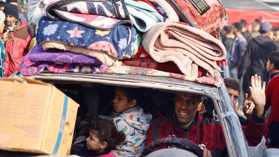Warga Palestina yang mengungsi berjalan melewati puing-puing saat mencoba kembali ke rumah mereka menyusul penundaan gencatan senjata antara Israel dan Hamas mengenai daftar sandera, di Jalur Gaza utara 19 Januari 2025. (REUTERS/Khalil Ramzi)