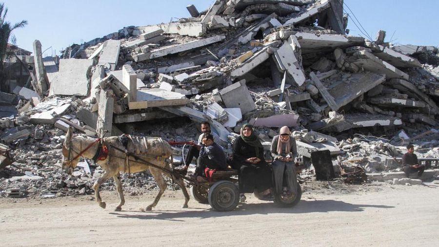 Warga Palestina yang mengungsi berjalan melewati puing-puing saat mencoba kembali ke rumah mereka menyusul penundaan gencatan senjata antara Israel dan Hamas mengenai daftar sandera, di Jalur Gaza utara 19 Januari 2025. (REUTERS/Khalil Ramzi)
