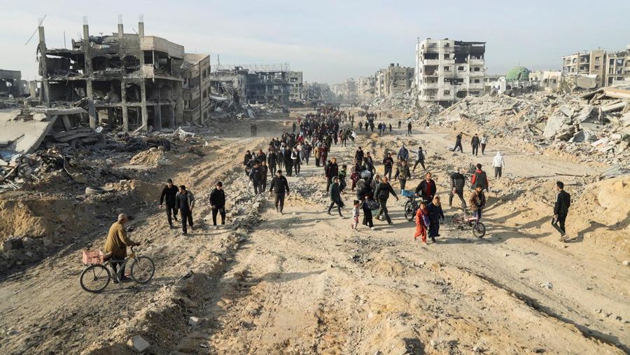 Warga Palestina yang mengungsi berjalan melewati puing-puing saat mencoba kembali ke rumah mereka menyusul penundaan gencatan senjata antara Israel dan Hamas mengenai daftar sandera, di Jalur Gaza utara 19 Januari 2025. (REUTERS/Khalil Ramzi)