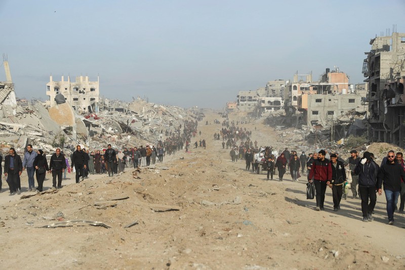 Warga Palestina yang mengungsi berjalan melewati puing-puing saat mencoba kembali ke rumah mereka menyusul penundaan gencatan senjata antara Israel dan Hamas mengenai daftar sandera, di Jalur Gaza utara 19 Januari 2025. Warga Palestina yang mengungsi berjalan melewati puing-puing saat mencoba kembali ke rumah mereka menyusul penundaan gencatan senjata antara Israel dan Hamas mengenai daftar sandera, di Jalur Gaza utara 19 Januari 2025. (REUTERS/Khalil Ramzi)