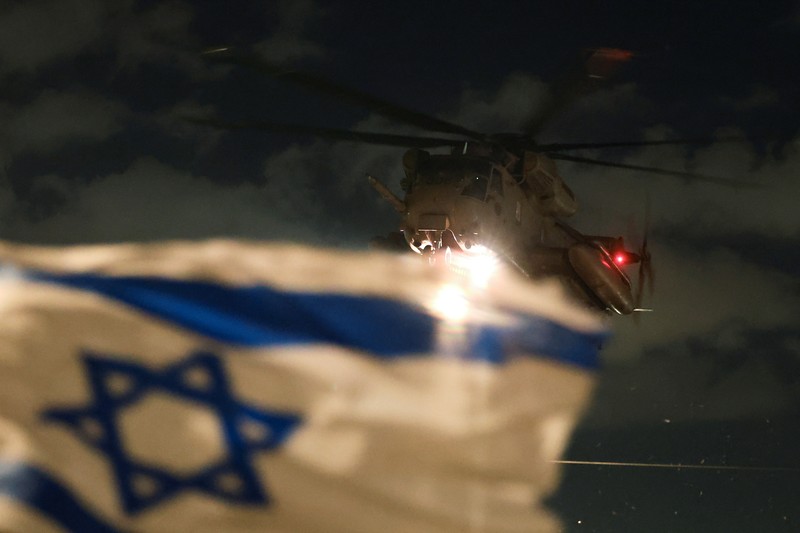 Militan Hamas Palestina berkumpul di sekitar kendaraan selama penyerahan sandera yang diculik selama serangan 7 Oktober 2023 di Israel oleh Hamas, kepada anggota Komite Palang Merah Internasional (ICRC) sebagai bagian dari gencatan senjata dan kesepakatan pertukaran sandera-tahanan antara Hamas dan Israel, di Kota Gaza, 19 Januari 2025. (REUTERS/Dawoud Abu Alkas)
