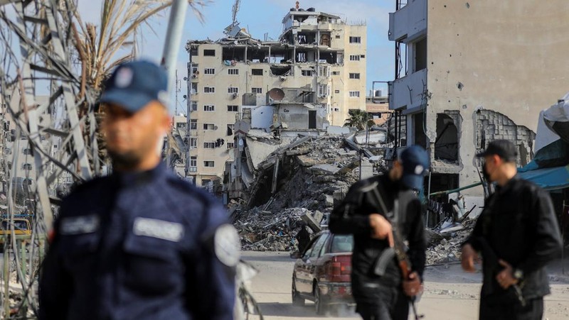 Palestinian Hamas policemen stand guard near the rubble after deploying in streets to maintain order, following a ceasefire between Israel and Hamas, in Gaza City, January 20, 2025. REUTERS/Dawoud Abu Alkas