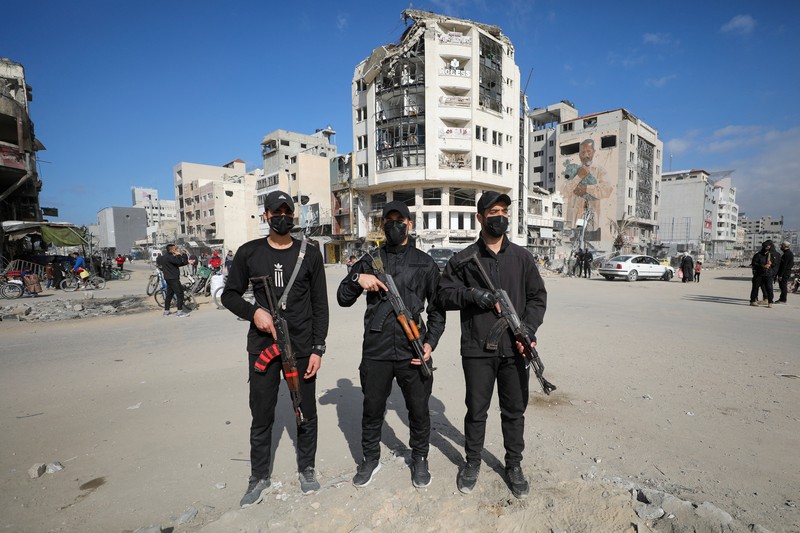 ISRAEL-PALESTINIANS/GAZA-CEASEFIRE-HAMAS-POLICE Palestinian Hamas policemen stand guard near the rubble after deploying in streets to maintain order, following a ceasefire between Israel and Hamas, in Gaza City, January 20, 2025. REUTERS/Dawoud Abu Alkas