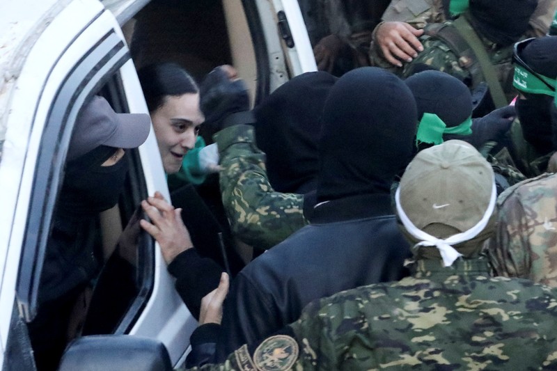 Militan Hamas Palestina berkumpul di sekitar kendaraan selama penyerahan sandera yang diculik selama serangan 7 Oktober 2023 di Israel oleh Hamas, kepada anggota Komite Palang Merah Internasional (ICRC) sebagai bagian dari gencatan senjata dan kesepakatan pertukaran sandera-tahanan antara Hamas dan Israel, di Kota Gaza, 19 Januari 2025. (REUTERS/Dawoud Abu Alkas)