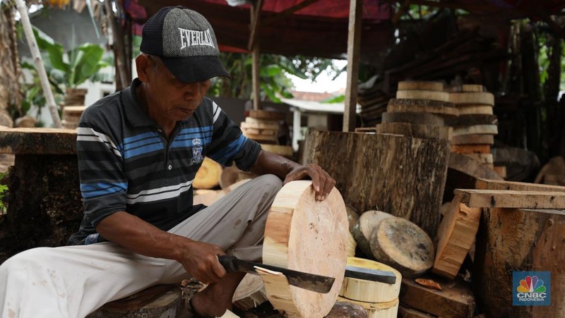 Pekerja menyelesaikan pembuatan talenan berbahan dasar kayu di Desa Sasak Panjang, Kecamatan Tatur Halang, Bogor, Jawa Barat, Senin (20/1/2025). (CNBC Indonesia/Tri Susilo)