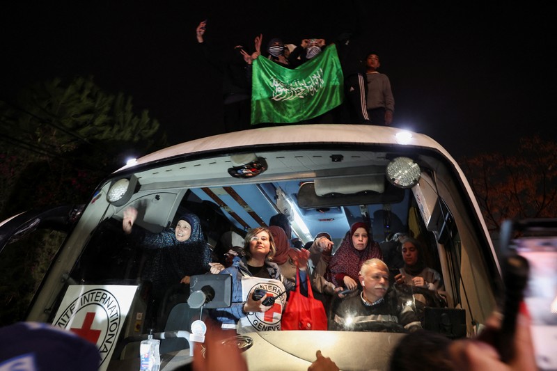 Orang-orang yang membawa bendera berdiri di atas bus saat mereka bereaksi terhadap kedatangan bus yang membawa warga Palestina yang dibebaskan dari penjara Israel sebagai bagian dari pertukaran sandera-tahanan dan kesepakatan gencatan senjata antara Hamas dan Israel, di Ramallah di Tepi Barat yang diduduki Israel. 20 Januari 2025. Orang-orang yang membawa bendera berdiri di atas bus saat mereka bereaksi terhadap kedatangan bus yang membawa warga Palestina yang dibebaskan dari penjara Israel sebagai bagian dari pertukaran sandera-tahanan dan kesepakatan gencatan senjata antara Hamas dan Israel, di Ramallah di Tepi Barat yang diduduki Israel. 20 Januari 2025. (REUTERS/Mussa Qawasma)