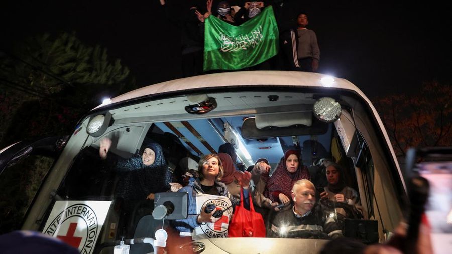 Orang-orang yang membawa bendera berdiri di atas bus saat mereka bereaksi terhadap kedatangan bus yang membawa warga Palestina yang dibebaskan dari penjara Israel sebagai bagian dari pertukaran sandera-tahanan dan kesepakatan gencatan senjata antara Hamas dan Israel, di Ramallah di Tepi Barat yang diduduki Israel. 20 Januari 2025. (REUTERS/Mussa Qawasma)